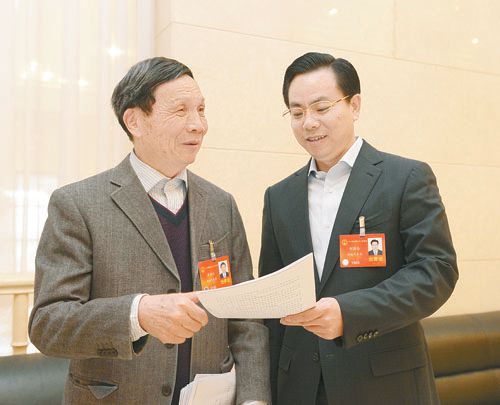 黃伯云代表（左）與劉國忠代表商討完善《關(guān)于建立戰(zhàn)略性新興產(chǎn)業(yè)國家創(chuàng)新平臺》的建議。 本報(bào)記者 張目 攝